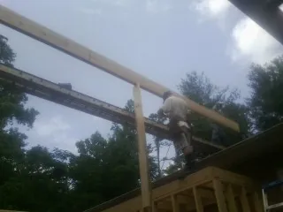 Carpenter setting a ridge beam over a new addition frame — Ice Dam Removal by Roofing Brothers in Kirklin