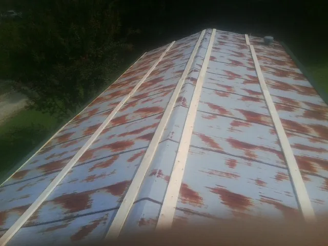 Rusted metal roof panels with new wood purlins before replacement — Storm Damage Roof Repair in Kirklin by Roofing Brothers