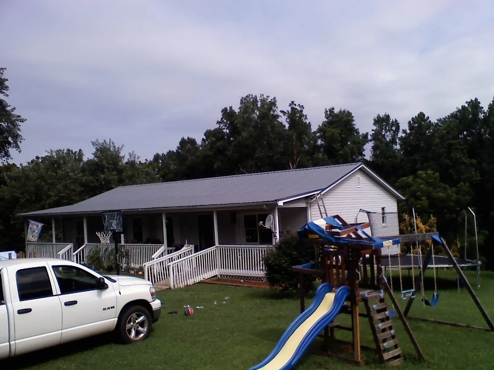 Dark metal roof on a country home with a full length front porch in Kirklin