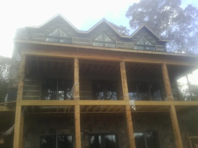 Dormers and porch framing on a large log home under construction — Roof Coating work by our crew in Kirklin
