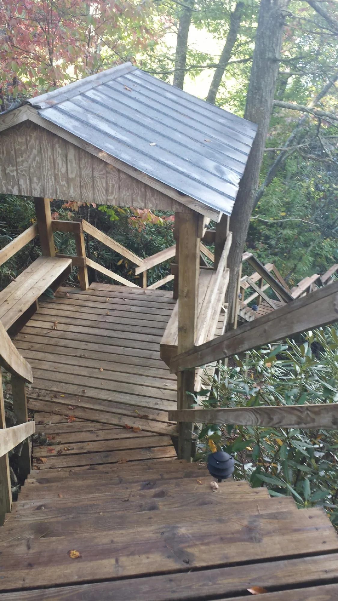 Metal roofed shelter over wooden steps on a wooded walkway — Skylight Repair & Installation work by our crew in Kirklin