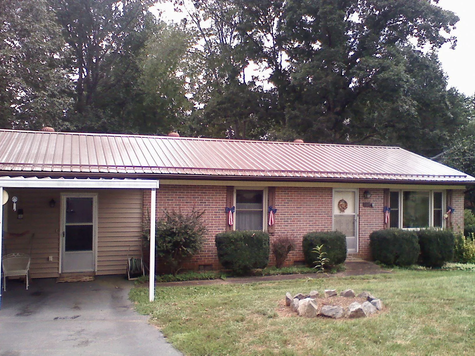 Bronze metal roof and carport on a brick ranch home — Roof Repair work by our crew in Kirklin